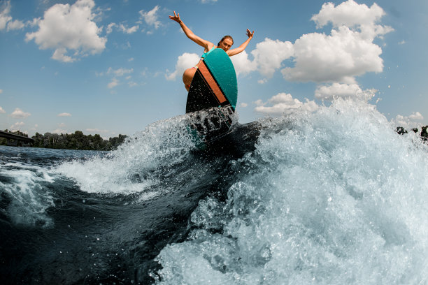 水花飞溅的河流波浪和活跃的女人与wakesurf熟练地跳上它的伟大的观点图片下载