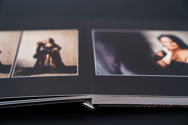 打开一本照片簿，从一个有魅力的女人在一个黑色背景的照片拍摄。图片下载