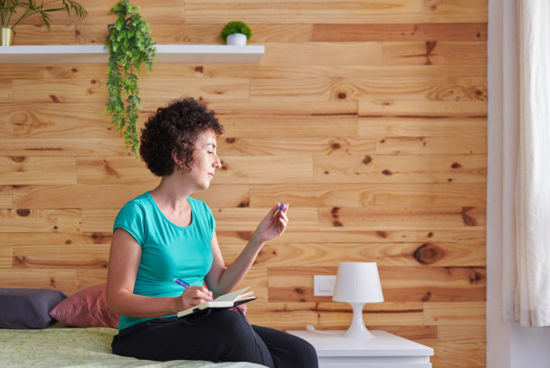 一位妇女正在看基础温度计来记录她的体温图片下载