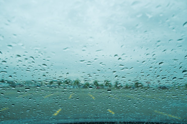 雨滴落在停车场的汽车挡风玻璃上图片下载