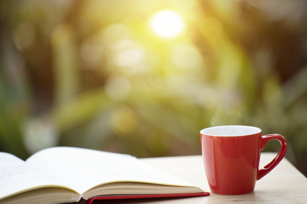 一杯咖啡和一本书在花园里图片下载