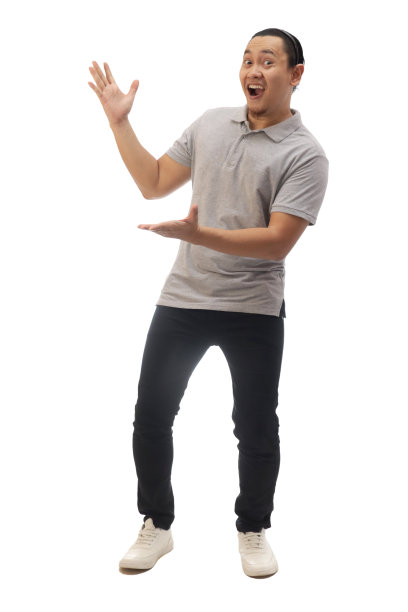 男人穿着休闲的灰色衬衫黑色牛仔布和白色的鞋子，微笑着指着或呈现在他身边的东西。全身肖像隔离图片下载