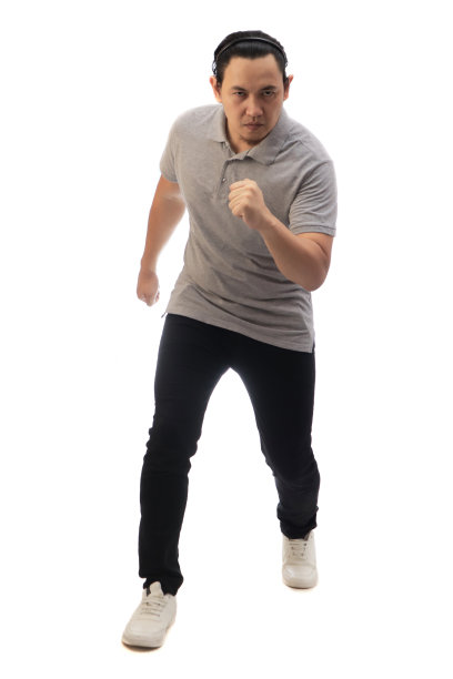 亚洲男子穿着灰色衬衫黑色牛仔布和白色鞋子，严肃地看着镜头，准备奔跑，正面观看。全身肖像隔离图片下载