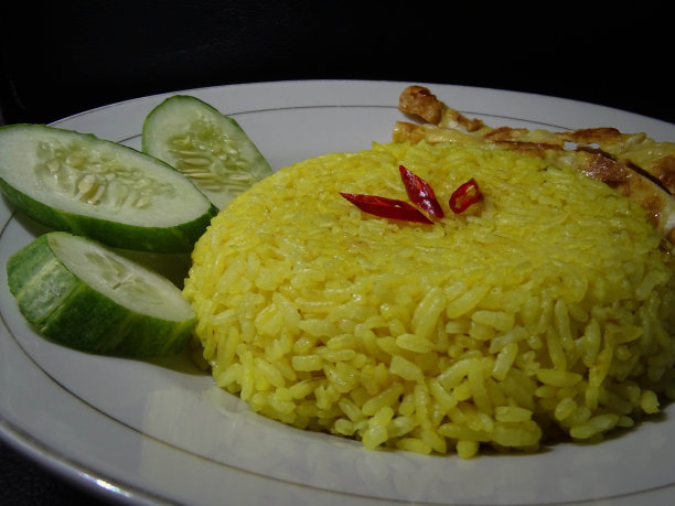 一盘黄色的米饭孤立在黑色背景上图片下载