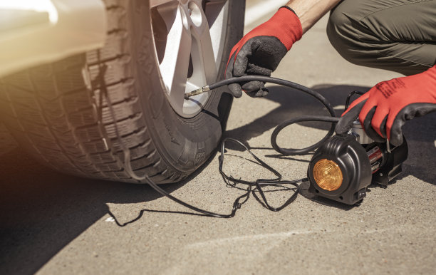 轮胎打气筒给汽车车轮充气。男性手拿轮胎充气机，用压力计检查压力图片下载
