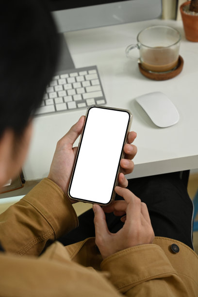 年轻人坐在工作场所使用智能手机。图片下载