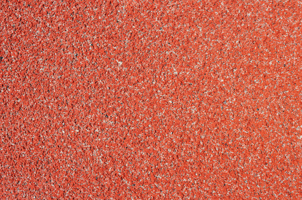 橡胶碎屑(橡胶沥青)的纹理用于体育场。用于运动场地，慢跑，跑道和自行车道的弹性涂料。图片下载