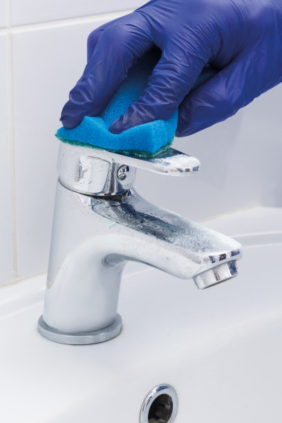 清洁公司员工清洁水龙头和水槽特写图片下载