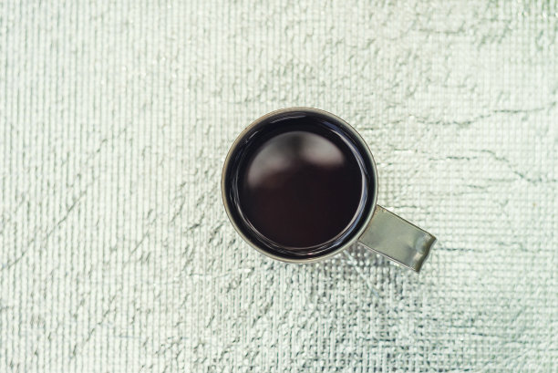 一杯茶或咖啡站在银色的金属背景图片下载