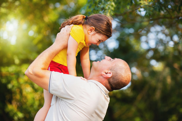 这是一张爸爸和他的小女儿一起在户外度过美好阳光日的特写照片。图片下载