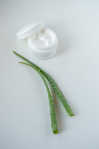 白色背景上的化妆霜和芦荟叶。图片下载