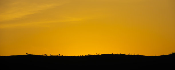 红色的天空在山上日落。图片下载