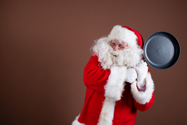 有趣的圣诞老人正在准备晚餐。图片下载