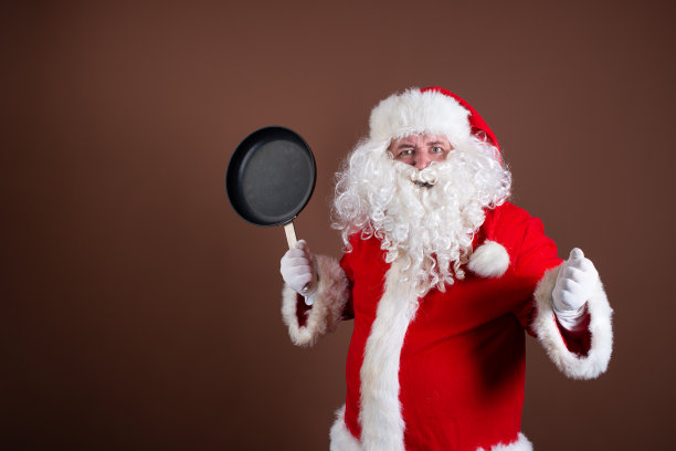 有趣的圣诞老人正在准备晚餐。图片下载