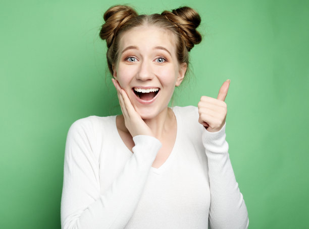 快乐的年轻白人女性竖起大拇指，微笑着图片下载