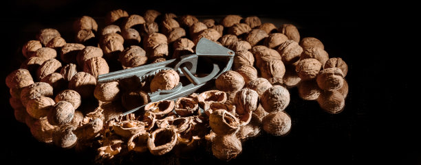 胡桃夹子里的胡桃。黑暗的背景。美丽的背景和食物。健康的成分。有用的营养素。美味的饮食小吃。宏。棕色螺母。艺术照片。简而言之工具。壁纸图片下载