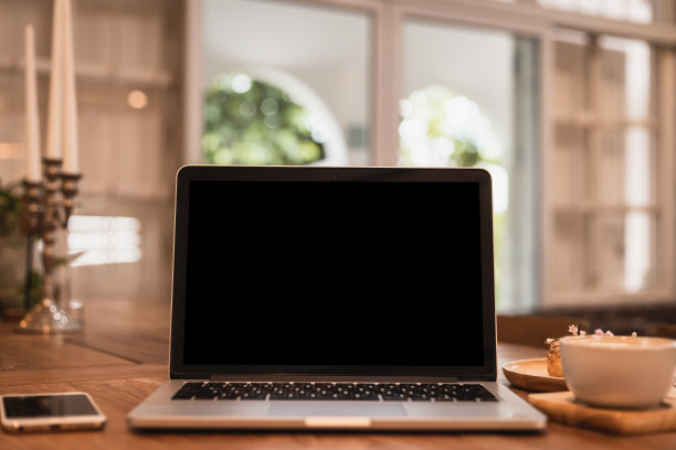 咖啡店背景的桌子上有空屏幕的笔记本电脑模型，黑色屏幕，咖啡杯和智能手机图片下载