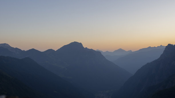 山顶上的夕阳。山脉的轮廓。天空的暖色。意大利阿尔卑斯山。山谷底部的湿度图片下载