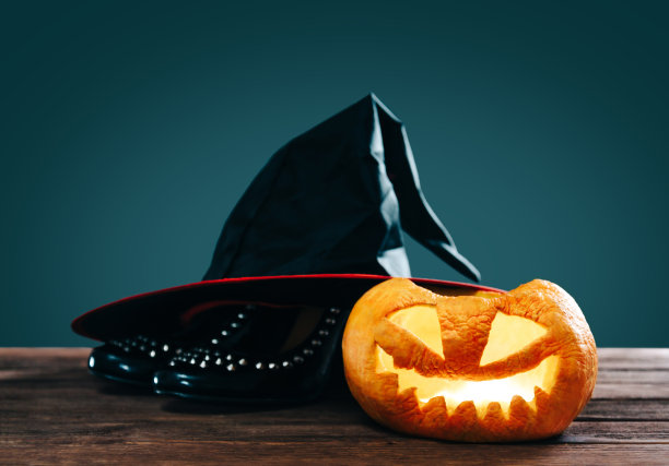 万圣节南瓜附近的黑鞋和女巫帽。图片下载