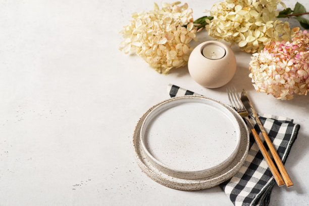 感恩节餐桌上有干花、盘子、餐具和白色背景上的蜡烛图片下载