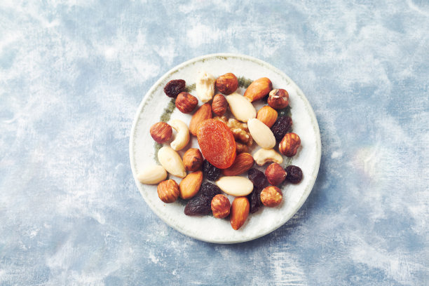 坚果，葡萄干和杏子在质朴的木制背景上。健康零食的概念。前视图。副本的空间。图片下载
