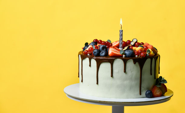 生日派对甜蛋糕巧克力滴新鲜水果树莓草莓蓝莓蔓越莓。蜡烛蛋糕图片下载