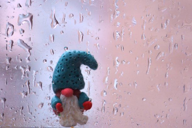 一个侏儒的身影出现在潮湿的窗户背景上。图片下载