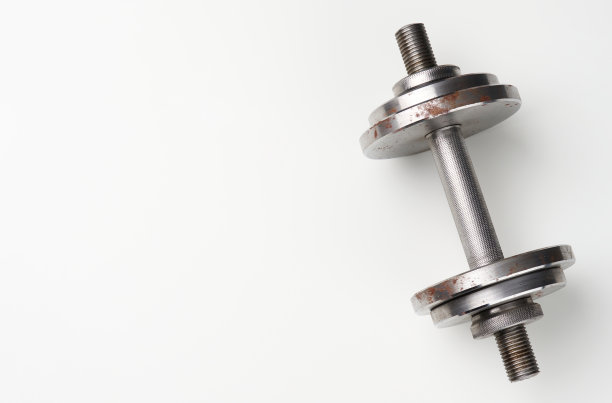 白色背景上有排字圈的金属哑铃，运动器材图片下载