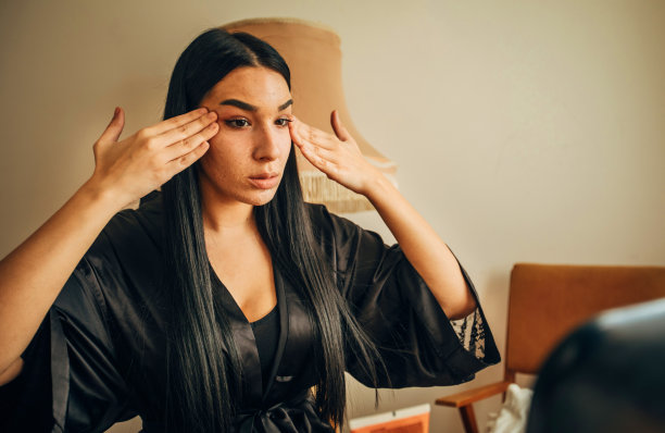 年轻女子在浴袍清洁她的脸在家里股票照片图片下载