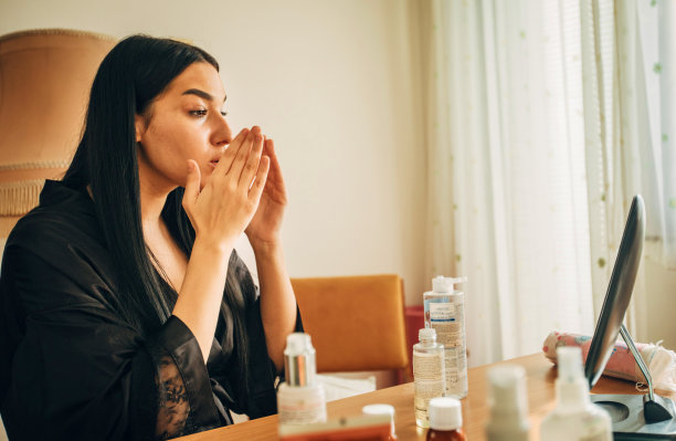 年轻女子在浴袍清洁她的脸在家里股票照片图片下载