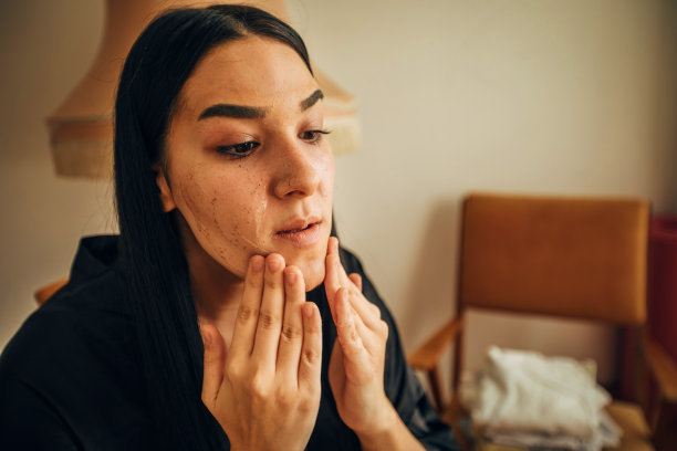 年轻女子在浴袍清洁她的脸在家里股票照片图片下载