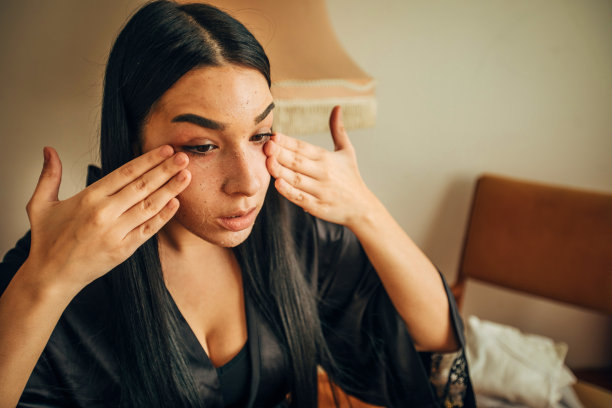 年轻女子在浴袍清洁她的脸在家里股票照片图片下载