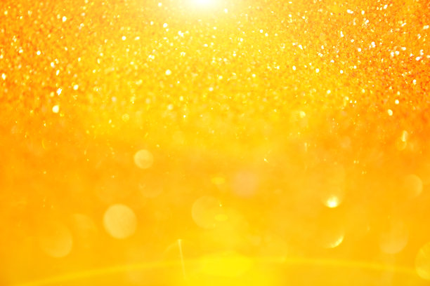 模糊的纹理的金色闪耀。背景有金色或黄色的亮片。无缝纹理与金黄色亮片。闪烁的背景图片下载