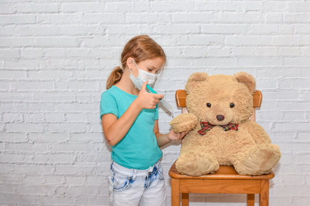 小女孩与注射器使注射疫苗玩具熊照片没有处理图片下载