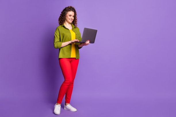 专注的女孩首席执行官员工的全身照片使用笔记本电脑工作copyspace手表培训研讨会网络研讨会穿绿色风格风格时尚时尚的服装孤立的紫罗兰色背景图片下载