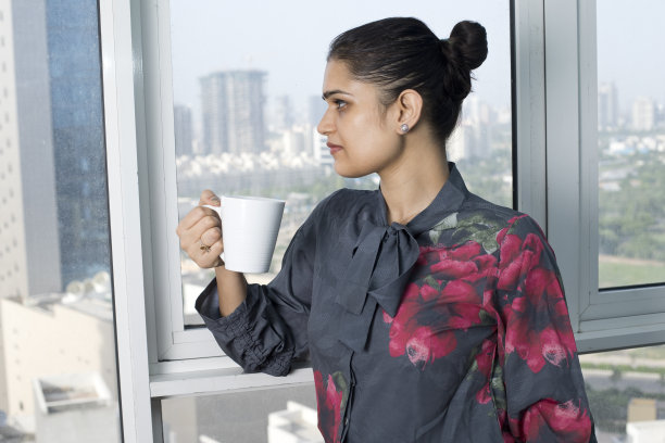 一个女人喝着咖啡，看着窗外图片下载