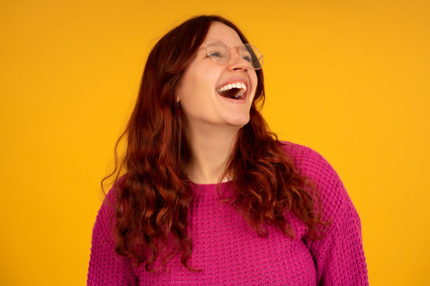 年轻女子微笑着站在一个孤立的背景。图片下载