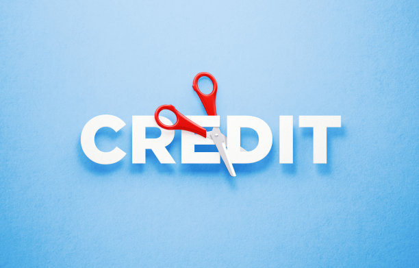 削减信贷供应概念-剪刀削减字信贷在蓝色背景图片下载