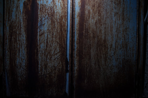 旧生锈的金属背景或纹理在黑暗的房间与光。关闭了。图片下载