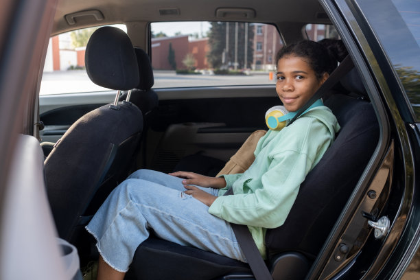 快乐的年轻女孩在车后座微笑着看着你图片下载