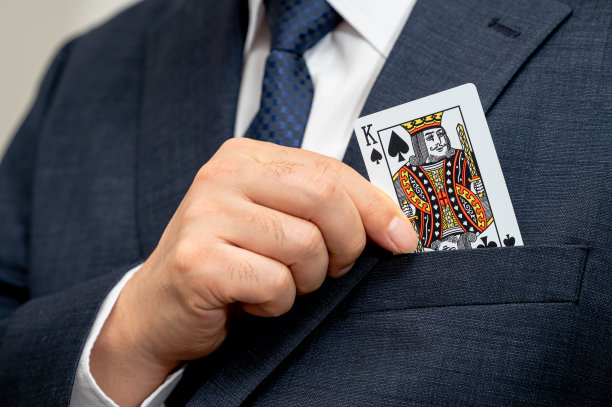 扑克之王牌在西装革履的商人手中。图片下载