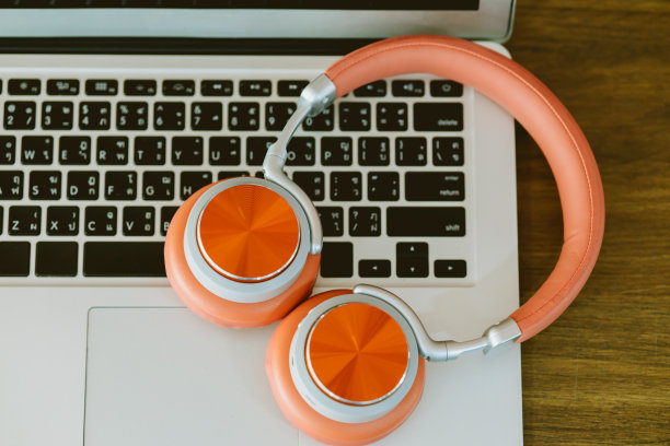 立体声耳机放在笔记本电脑键盘上工作和听音乐放松的概念图片下载