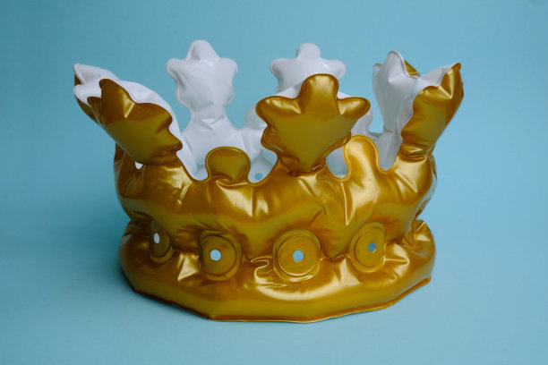 蓝色背景上的金色充气皇冠。图片下载
