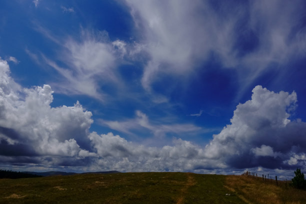 在奥地利山区徒步旅行时，蓝天上令人惊叹的云朵图片下载