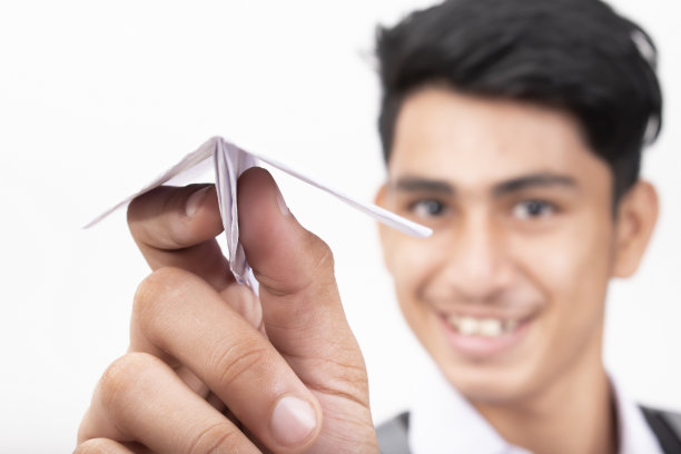 上学男孩展示纸飞机照片图片下载