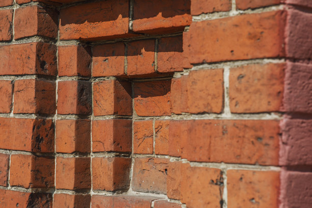 由旧红砖砌成的19世纪建筑的一部分墙。城市背景与美丽的建筑形状。水平的照片图片下载
