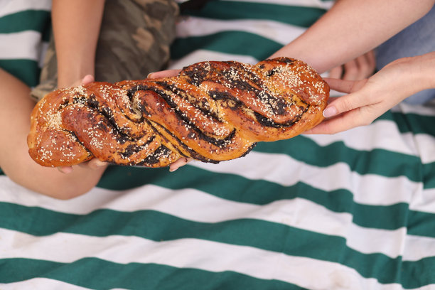 美味的羊皮纸牛角包在篮子在阳光明媚的户外野餐。在温暖的阳光下俯瞰新鲜出炉的牛角面包。美味的面包和小吃在聚会或野餐。真实的图片图片下载