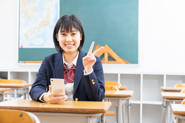 亚洲女学生在教室里学习，智能手机，制服，图片下载