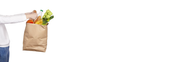 购物，食物运送或捐赠的概念。杂货店购物。女人拿着环保纸袋装满了食品杂货，水果，蔬菜，酸奶，鸡蛋隔离在白色的长旗与复印空间。图片下载
