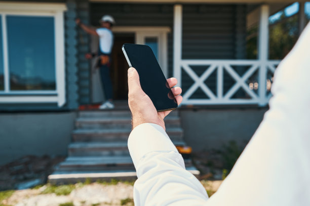 建筑工人拿着智能手机的裁剪照片图片下载